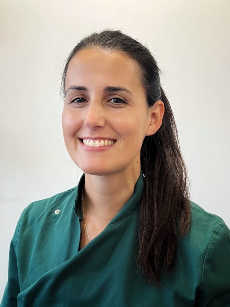 A head and shoulders image of a woman in veterinary scrubs smiling at the camera.