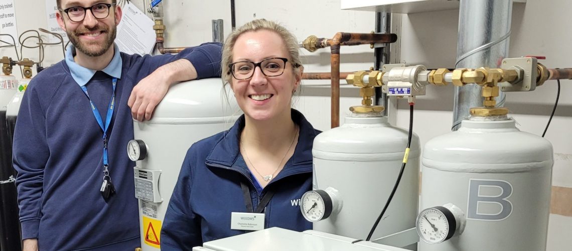 An Image of two members of the Willows team standing next to a new Atlas Copco oxygen generator